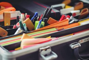 assorted pen and colored papers in organizer case for a teacher