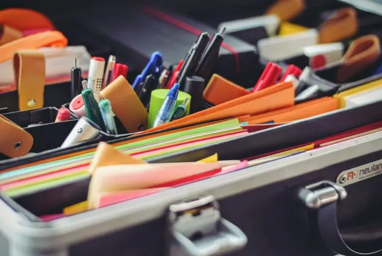assorted pen and colored papers in organizer case for a teacher