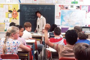 woman teacher standing in front of children