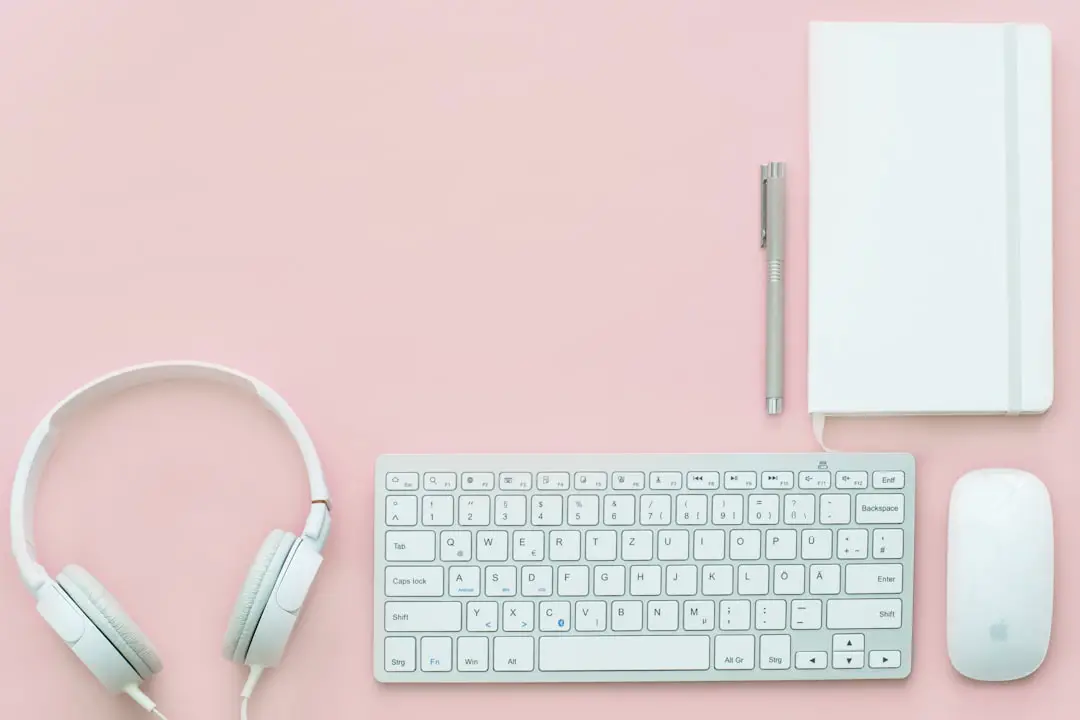 White gear on pink flatlay by Teacher Supply Store white Apple Magic Mouse beside of Magic Keyboard and headphones