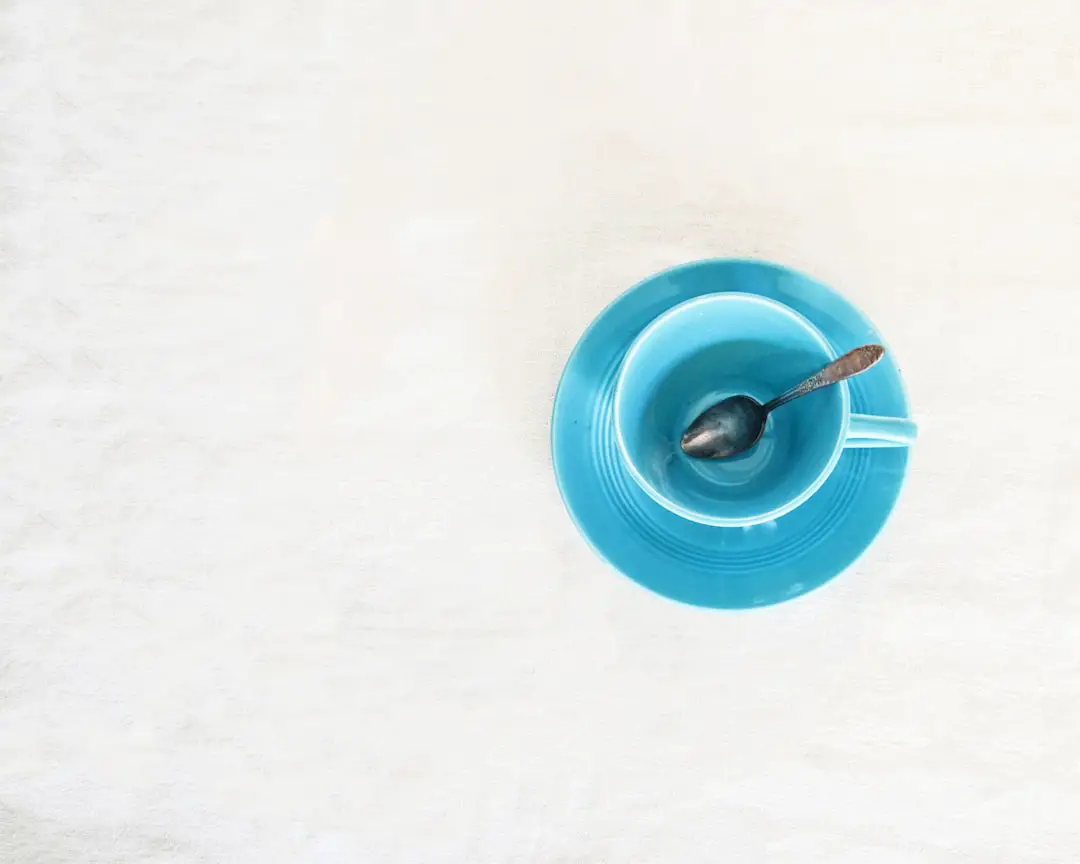 An empty vintage blue teacup waiting to be filled. The spoon was part of my mom’s wedding silver. by Teacher Supply Store a blue bowl with a spoon inside of it