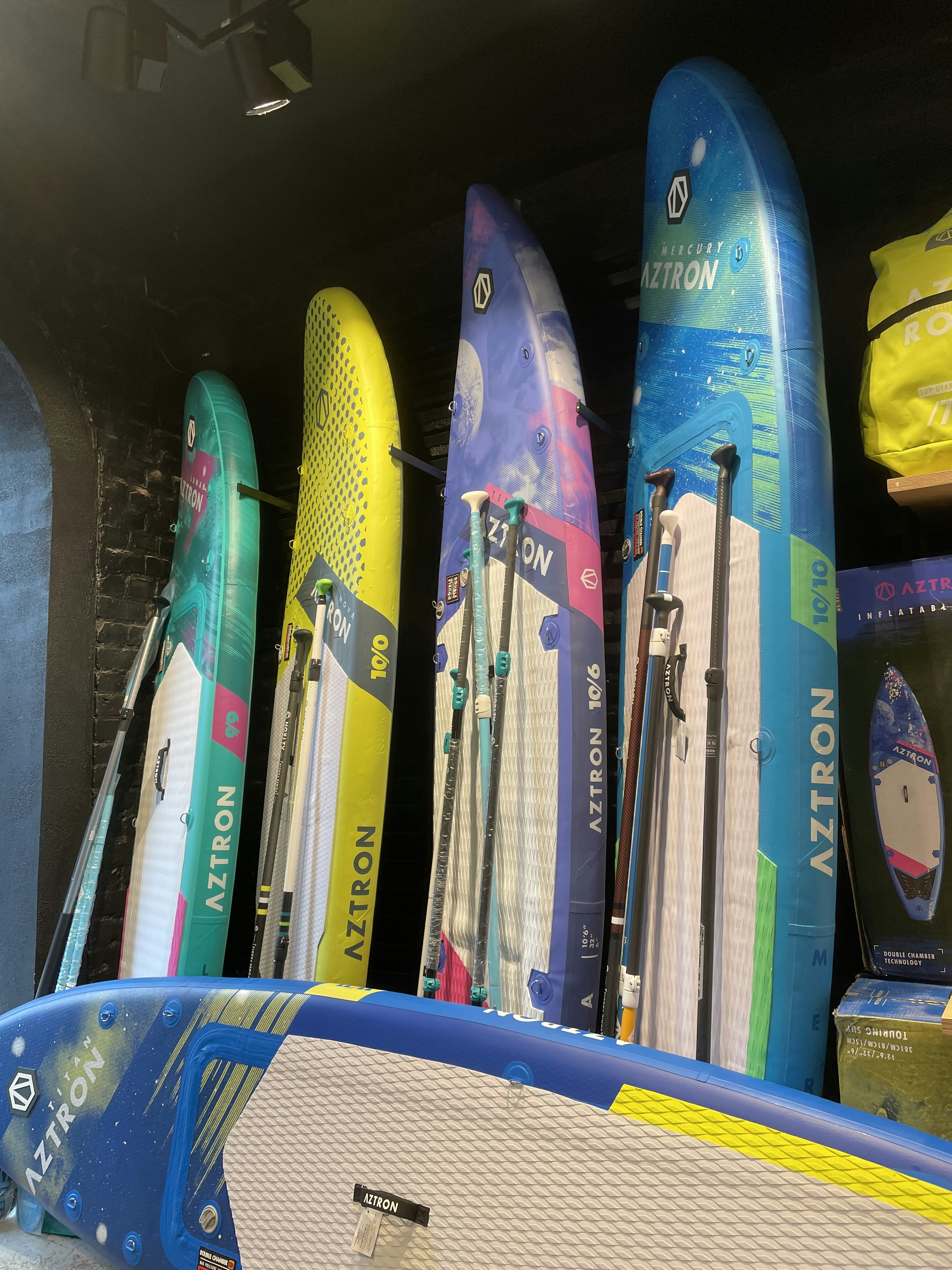 a bunch of surfboards are lined up on a shelf