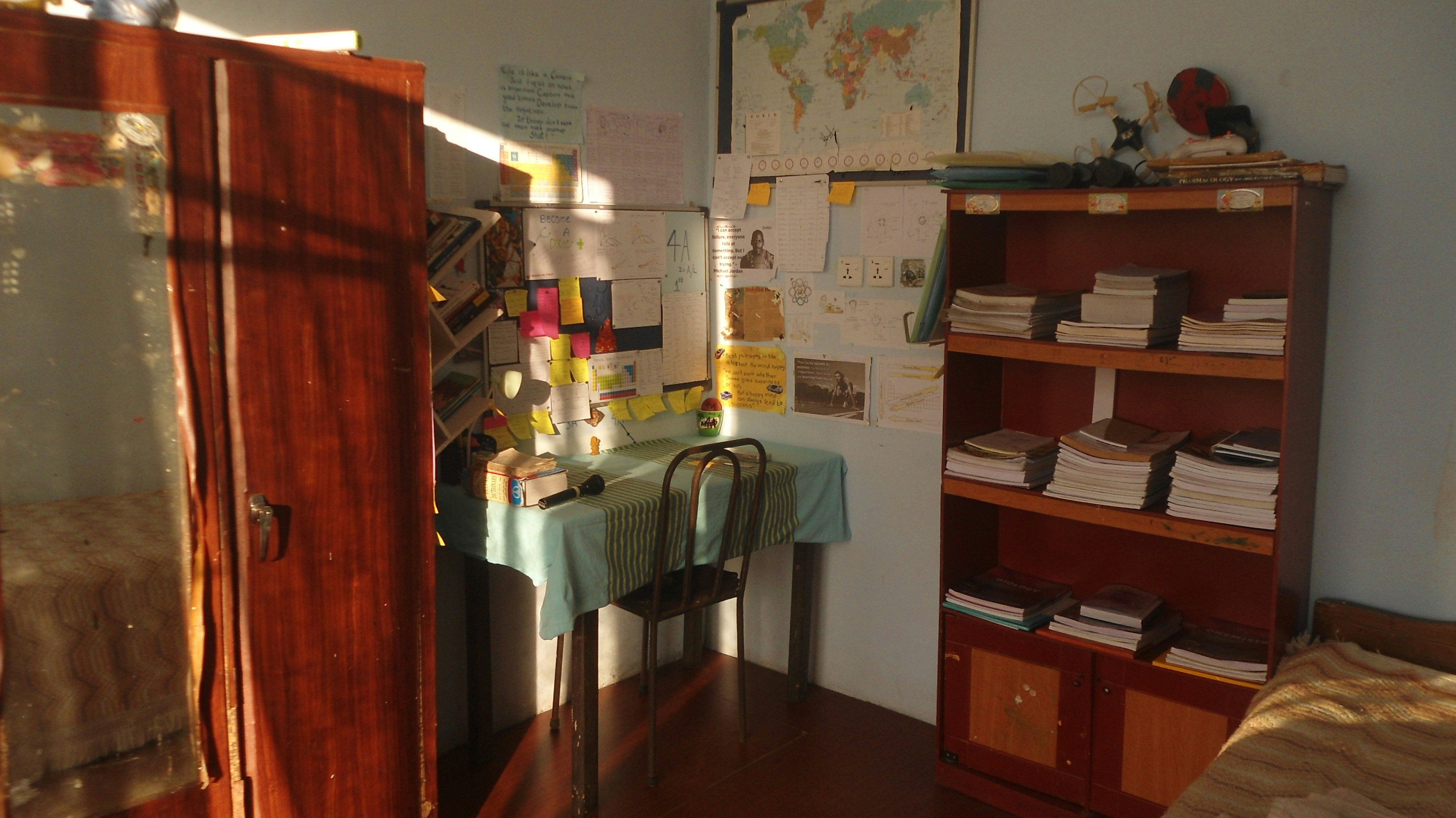 An organized room with desk, shelves, and wardrobe.